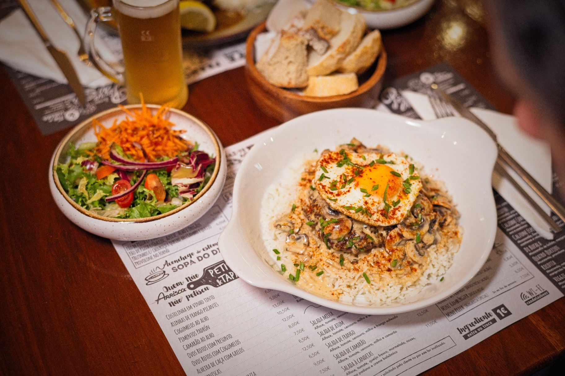 Prato de arroz com carne, cogumelos e ovo estrelado servido no Candeias